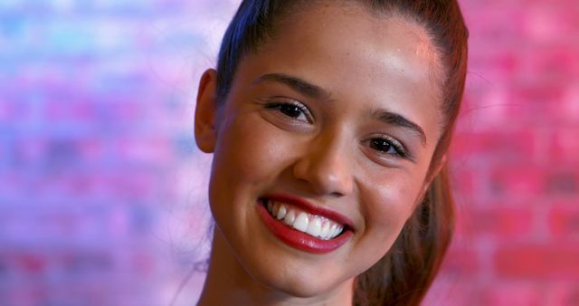 Smiling Young Woman with Cheerful Expression in Front of Colorful Background - Download Free Stock Images Pikwizard.com