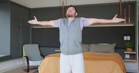 Mature man practicing mindfulness in modern bedroom