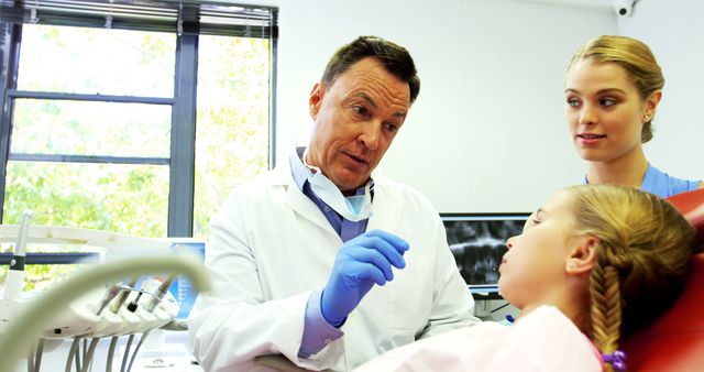 Dentist Explaining Procedure to Young Patient with Concerned Parent - Download Free Stock Images Pikwizard.com