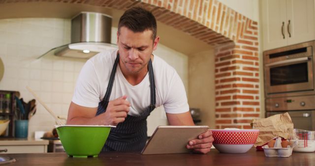 Concentrated Man Using Tablet While Cooking in Modern Kitchen - Download Free Stock Images Pikwizard.com