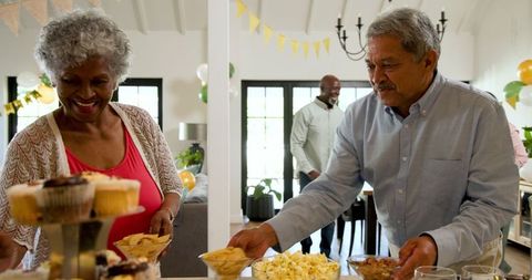 Senior Friends Preparing Birthday Party Celebration at Home