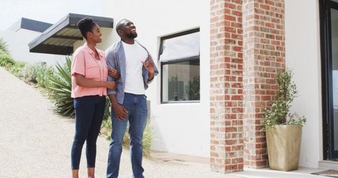Happy Couple Together Viewing House in Bright Outdoor Setting