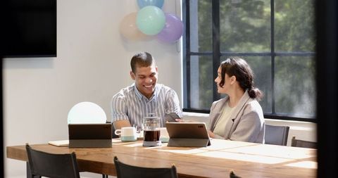 Happy Multiracial Colleagues Celebrating in Office with Coffee and Balloons