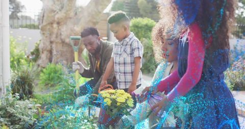 Sunlit Backyard Family Planting and Watering Yellow Flowers, Parents and Children Gardening Together