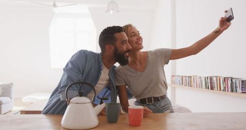 Happy couple enjoying weekend relaxation at home taking selfie