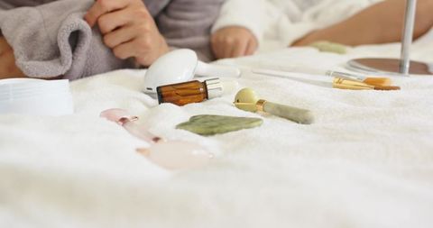 Calming spa tools on plush towel with jade roller, gua sha and amber oil for couple ritual