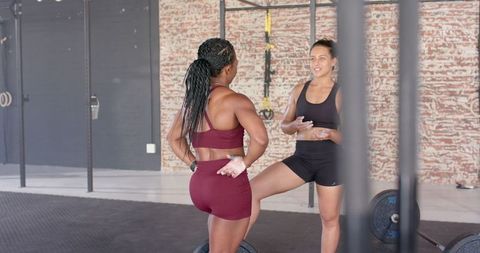 Women discussing workout plans in modern gym setting