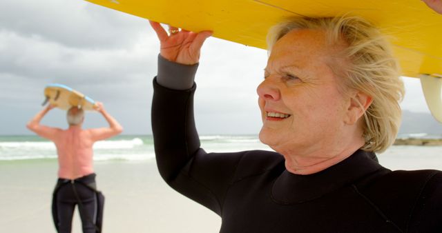 Senior Couple Carrying Surfboards on the Beach in Wetsuits - Download Free Stock Images Pikwizard.com