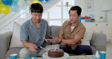 Father and Son Celebrating Birthday at Home with Chocolate Cake