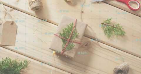Featuring kraft-wrapped gift tied with red twine and green sprig on rustic wood tabletop