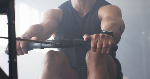 Muscular Man Focused on Vigorous Rowing Machine Workout