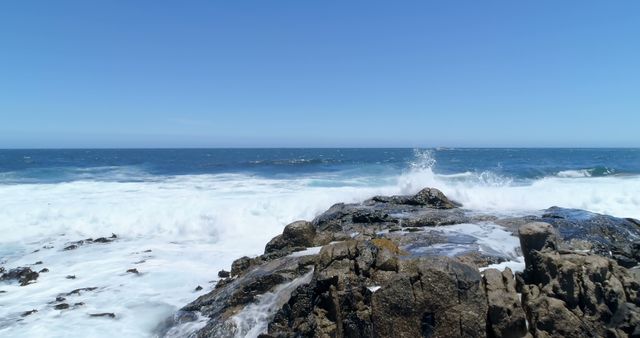 Rocky Shoreline With Waves Crashing Under Clear Blue Sky - Download Free Stock Images Pikwizard.com
