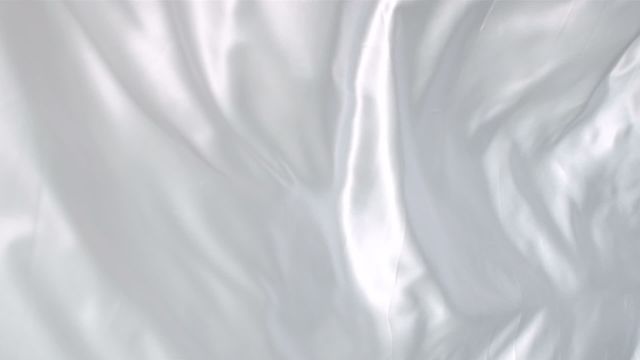 Smooth white fabric gently flowing in the breeze capturing streaming motion. Ideal for clean, soft-themed backgrounds, advertising for textiles or luxury linens, as well as projects needing a subtle and elegant touch.