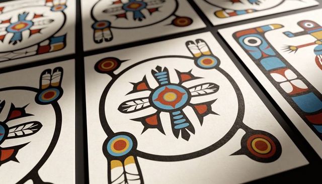 Printed card featuring circular feather motif and bold geometric color print on dark grid