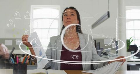 Woman analyzing data in modern office with futuristic graphics