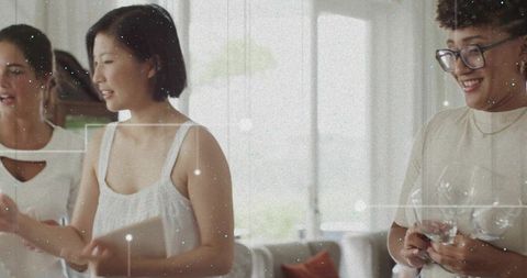 Three Women Chatting, Sharing Tablet and Smartphone in Sunlit Modern Living Room, Laughing