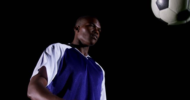 Focused Young Man Heading Soccer Ball at Night - Download Free Stock Images Pikwizard.com