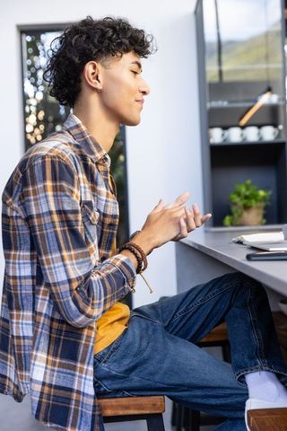 Casual young man focusing on work at modern home desk