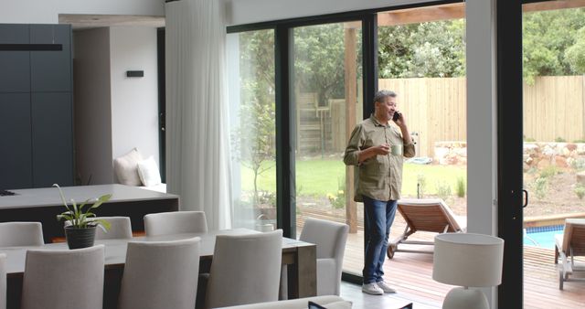 Senior Man Talking on Phone at Home by Window with Garden View - Download Free Stock Images Pikwizard.com