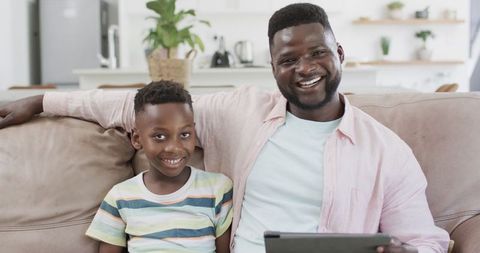 Father and Son Smiling with Tablet in Cozy Home Environment - Download Free Stock Images Pikwizard.com