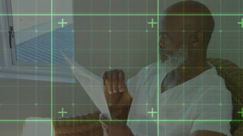 Senior Man Reading Document with Digital Graphic Overlay