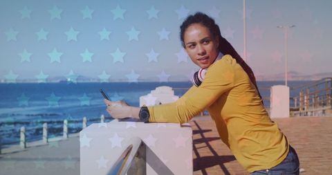 Confident Woman Using Smartphone on Ocean Promenade