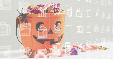 Halloween jack-o-lantern candy bucket overflowing with sweets and business icon digital overlay