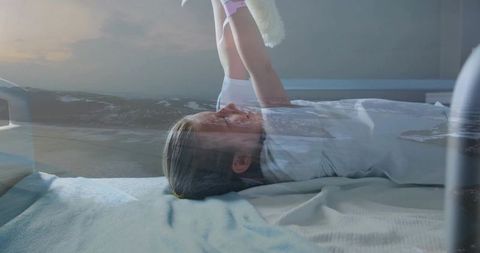 Dreamlike pediatric recovery double exposure with ocean horizon, child holding plush toy