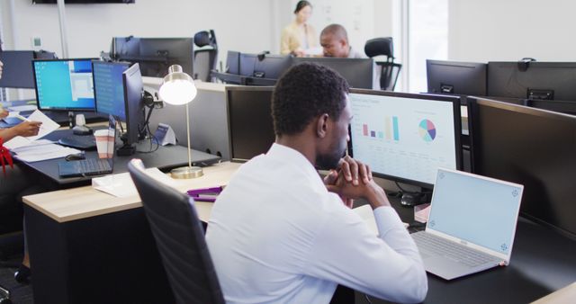 Businessman Analyzing Data on Dual Monitors in Modern Office - Download Free Stock Images Pikwizard.com