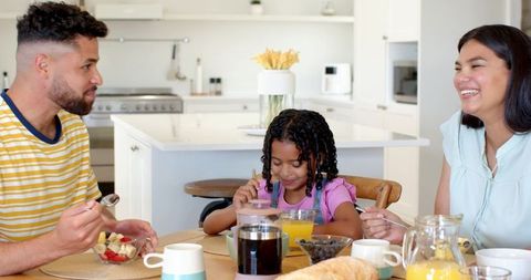 Diverse family enjoying breakfast together in modern kitchen