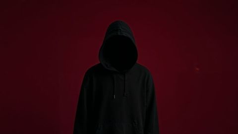 Mysterious hooded assassin figure in dark minimalism