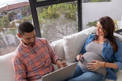 Expectant Couple Relaxing with Laptop and Ultrasound