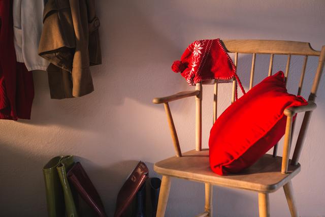 Cozy Wooden Chair with Red Pillow and Winter Hat - Download Free Stock Photos Pikwizard.com