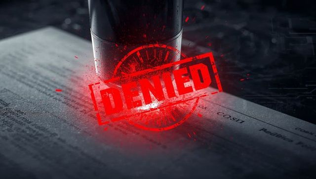 Stamping red denied seal on document with glowing ink and tech circuitry background