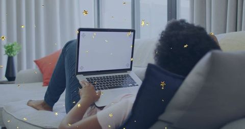 Relaxing on sofa with blank laptop screen for remote work and cozy living room gold stars