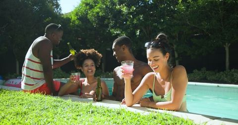 Friends Enjoying Refreshing Drinks by Sunny Backyard Pool