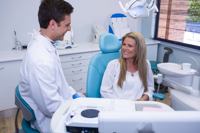 Happy patient talking with dentist at dental clinic