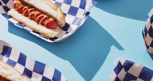 Image of hot dogs with mustard and ketchup on a blue surface. food, cuisine and catering ingredients.