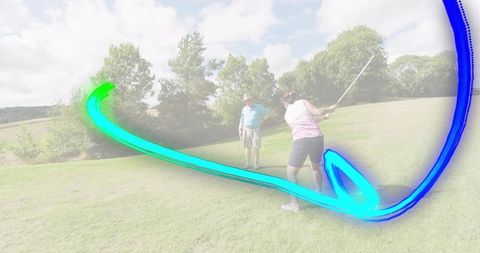 Senior woman swinging golf club with neon blue-teal motion trail on sunny fairway