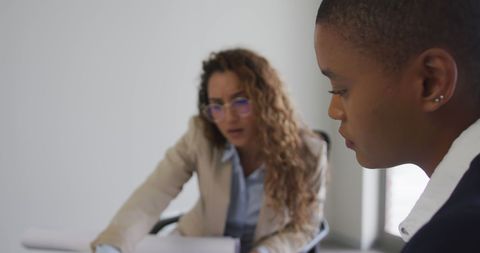 Focused Female Architects Reviewing Plans in Office Setting