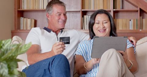 Diverse Couple Shopping Online at Home Using Tablet