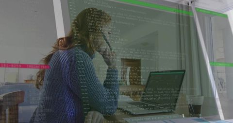 Woman programmer analyzing code on laptop screen