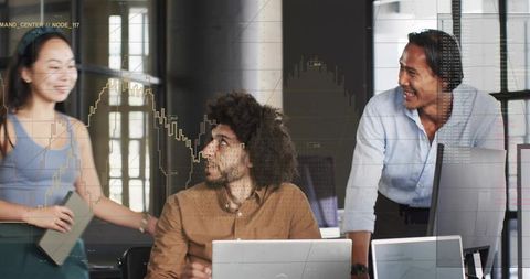 Diverse team collaborating around laptops analyzing financial charts in modern office