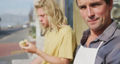 Surfboard Makers Relaxing During Break Outside Workshop