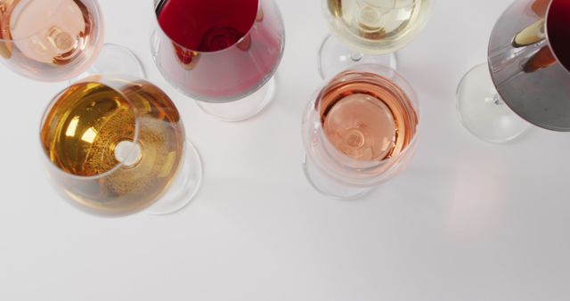 Assorted wine glasses filled with different wine types viewed from above. Ideal for use in advertisements for wine brands, festive events, alcohol promotions, party invitations, and culinary books.