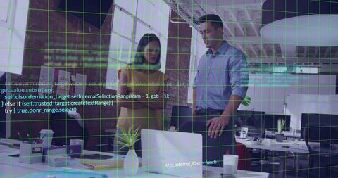Two Colleagues Collaborating Over Laptop with Code Overlay and Green Grid in Modern Office