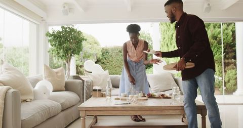 Joyful couple preparing living room for celebration gathering