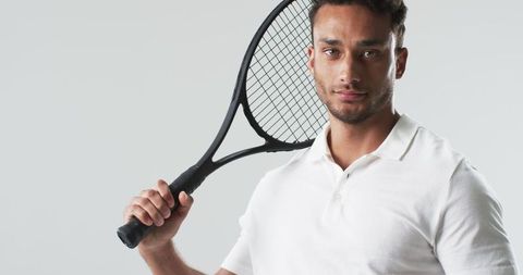 Sporty Young Man Holding Tennis Racket in White Polo