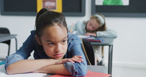 Bored Schoolgirl Leaning on Desk in Classroom - Download Free Stock Images Pikwizard.com