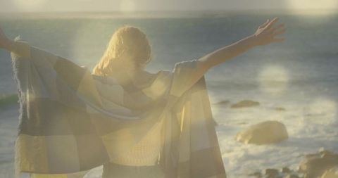 Woman Embracing Ocean Breeze on Rocky Shoreline